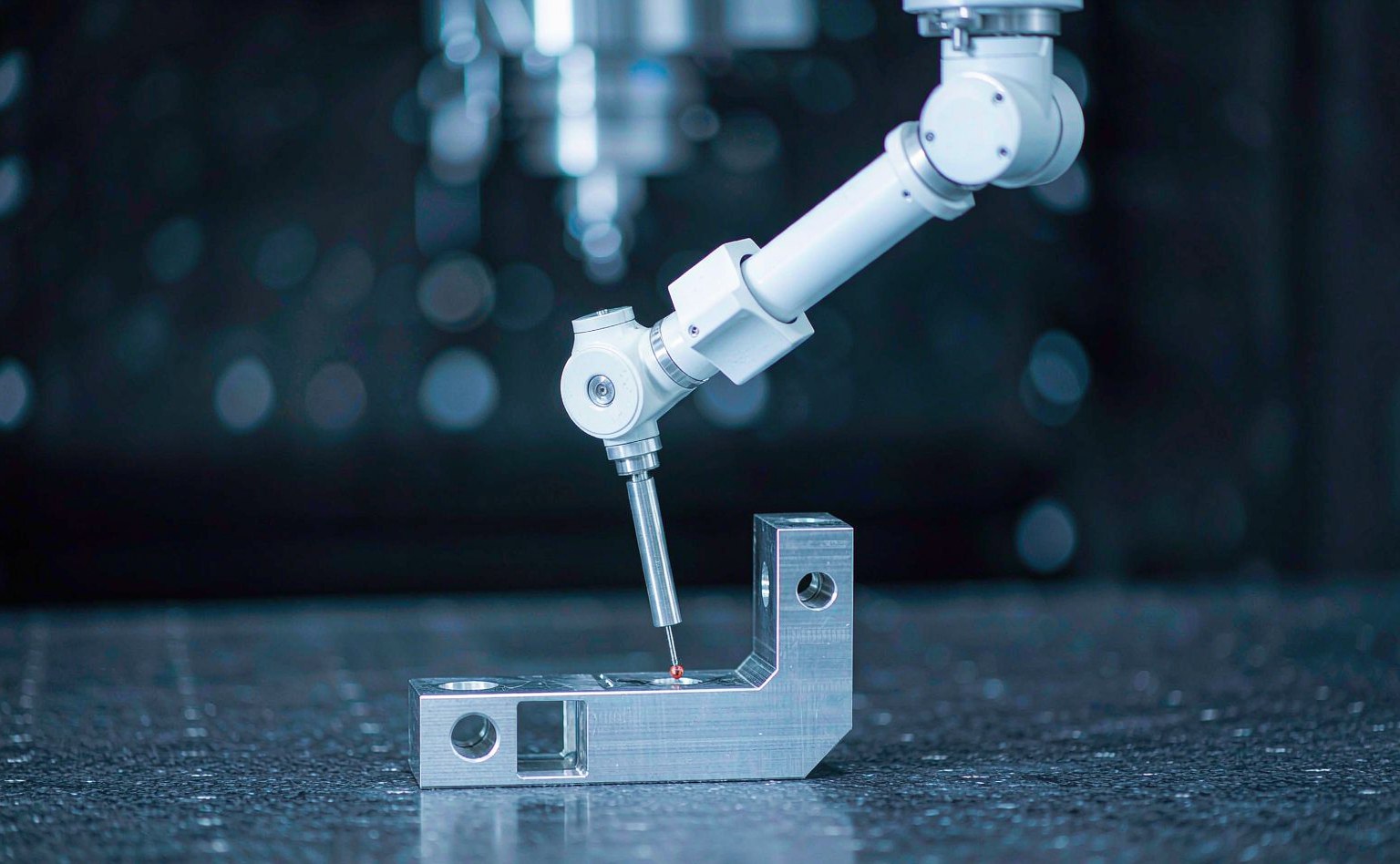 Coordinate measuring machine probing a machined aluminium bracket